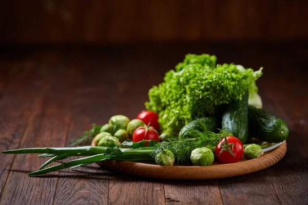 Vegetarisk stilleben av färska grönsaker på träplatta över rustika bakgrund, närbild, platt lay. — Stockfoto