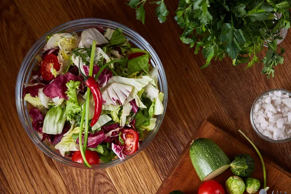 Salade de légumes frais et légumes mûrs sur planche à découper sur fond bois, gros plan, mise au point sélective — Photo