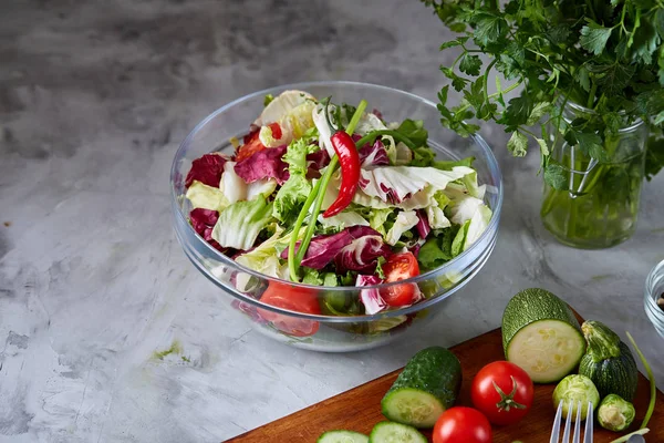 Frischer Gemüsesalat und reifes Gemüse auf Schneidebrett vor weißem Hintergrund, Nahaufnahme, selektiver Fokus — Stockfoto