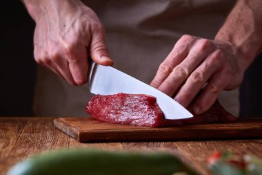 Güçlü profesyonel kesme çiğ biftek, seçici odak, yakın çekim yakışıklı adamın