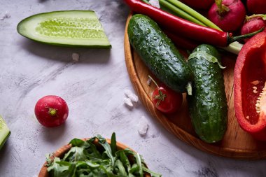 Bir vejetaryen salata beyaz dokulu arka plan, yakın çekim, seçici odak için sebzeli ahşap plaka