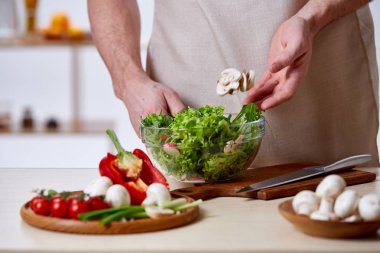 Adam seçici odak sağlıklı sebze salatası, yakın çekim, yapım mutfak yemek.