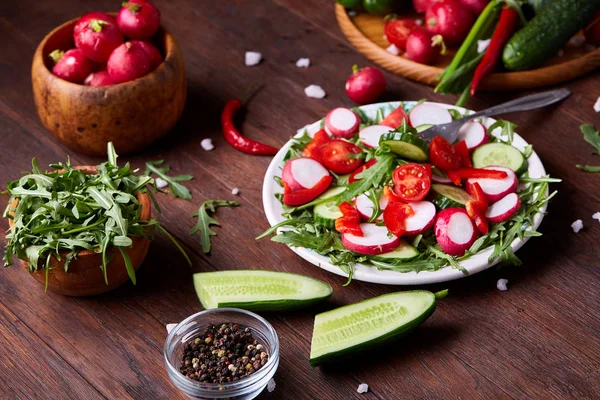 Salada de legumes frescos criativos com ruccola, pepino, tomate e rabdish na placa branca, foco seletivo — Fotografia de Stock