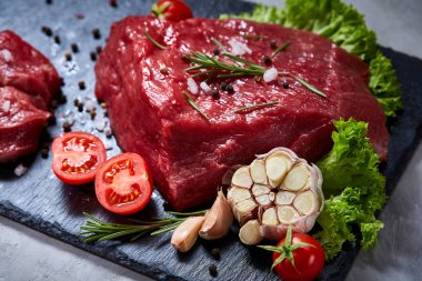 Sebze ile kayrak yönetim kurulu ve baharat, seçici odak, yakın çekim çiğ biftek bileşimi.