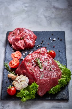 Sebze ile kayrak yönetim kurulu ve baharat, seçici odak, yakın çekim çiğ biftek bileşimi.