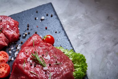 Sebze ile kayrak yönetim kurulu ve baharat, seçici odak, yakın çekim çiğ biftek bileşimi.