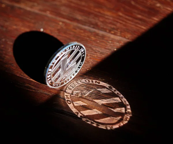 Moneda de plata de criptomoneda digital con el símbolo de Litecoin sobre un fondo de madera, primer plano, macro —  Fotos de Stock