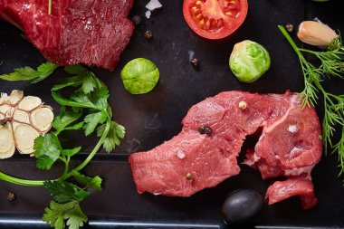 Sebzeler, otlar ve metal tepsi, yakın çekim, seçici odak spicies çiğ biftek düz lay