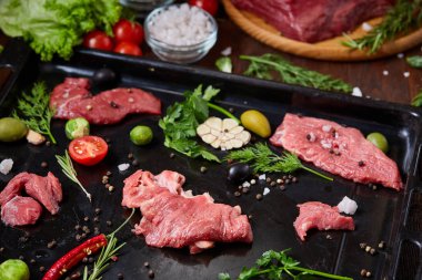 Sebzeler, otlar ve metal tepsi, yakın çekim, seçici odak spicies çiğ biftek düz lay