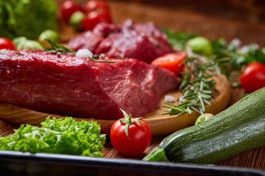 Natürmort ham sığır eti beyaz arka plan, üstten görünüm, seçici odak ahşap plaka üzerinde sebzeli