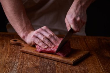 Güçlü profesyonel kesme çiğ biftek, seçici odak, yakın çekim yakışıklı adamın