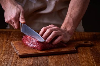 Güçlü profesyonel kesme çiğ biftek, seçici odak, yakın çekim yakışıklı adamın