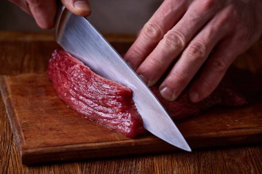 Güçlü profesyonel kesme çiğ biftek, seçici odak, yakın çekim yakışıklı adamın