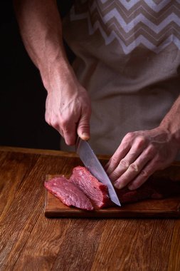 Güçlü profesyonel kesme çiğ biftek, seçici odak, yakın çekim yakışıklı adamın