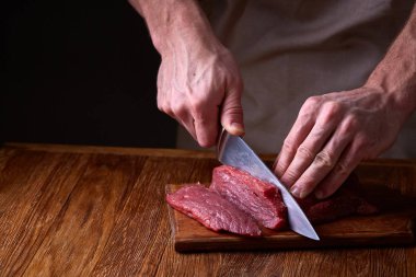 Güçlü profesyonel kesme çiğ biftek, seçici odak, yakın çekim yakışıklı adamın