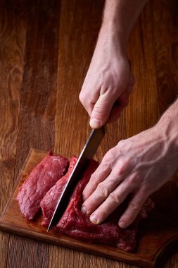 Güçlü profesyonel kesme çiğ biftek, seçici odak, yakın çekim yakışıklı adamın