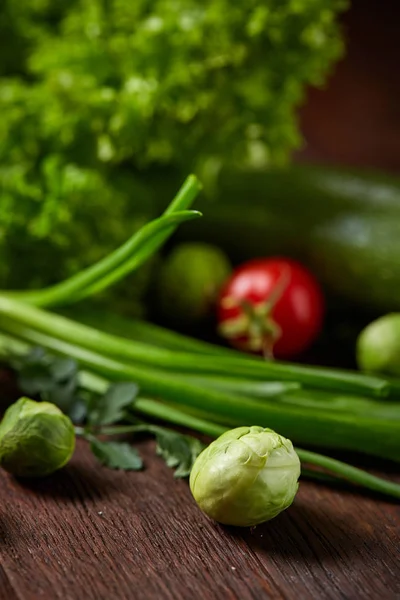 Nature morte végétarienne de légumes frais sur assiette en bois sur fond rustique, gros plan, plat . — Photo