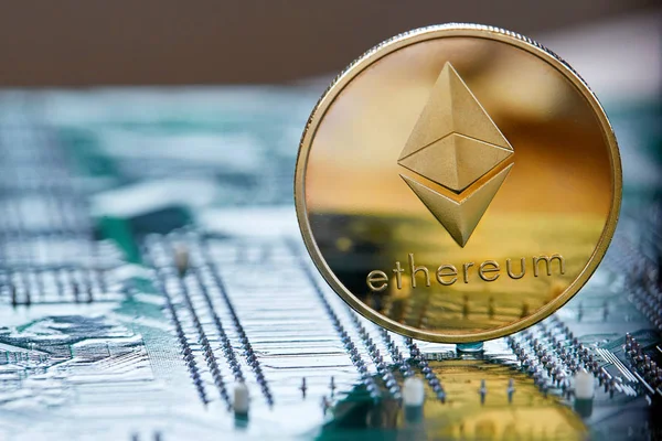 Golden ethereum coin cryptocurrency on a computer mainboard, selective focus, close-up. — Stock Photo, Image