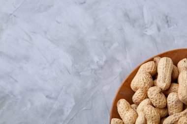 Ahşap kase beyaz dokulu arka plan closeup, seçici odak içinde soyulmamış fıstık