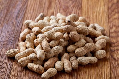 Ahşap arka plan, üstten görünüm, seçici odak, sığ derinlik-in tarla soyulmamış fıstık.