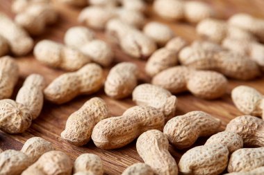 Ahşap arka plan, üstten görünüm, seçici odak, sığ derinlik-in tarla soyulmamış fıstık.