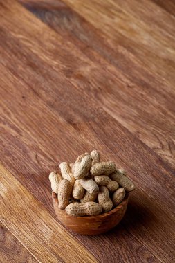 Ahşap kase rustik ahşap arka plan closeup, seçici odak içinde soyulmamış fıstık