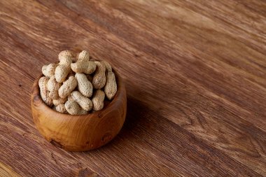 Ahşap kase rustik ahşap arka plan closeup, seçici odak içinde soyulmamış fıstık