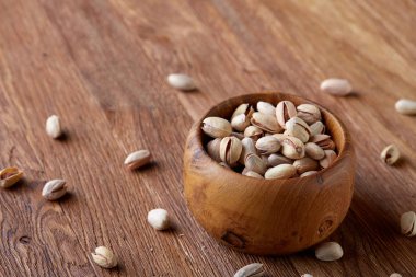 Badem ahşap arka plan, üstten görünüm, seçici odak kahverengi kase.