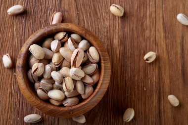 Badem ahşap arka plan, üstten görünüm, seçici odak kahverengi kase.