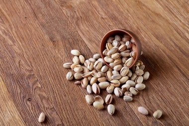 Pistachious ahşap arka plan, üstten görünüm, seçici odak ile devrilmiş seramik kase.