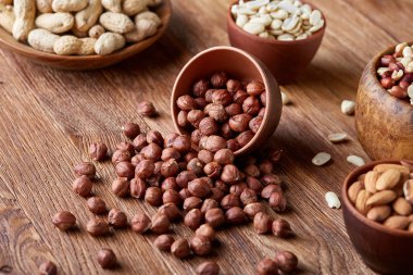 Bir kompozisyon farklı rustik arka plan, yakın çekim, sığ derinlik-in tarla ahşap bir kase içinde fındık çeşitleri