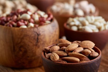 Bir kompozisyon farklı rustik arka plan, yakın çekim, sığ derinlik-in tarla ahşap bir kase içinde fındık çeşitleri