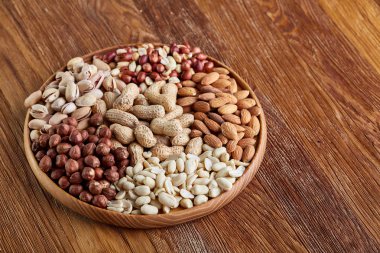 Karışık Kuruyemiş arrenged rustik arka plan, yakın çekim, seçici odak ahşap tepsi.