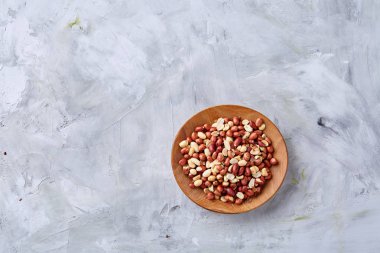 Ahşap plaka izole beyaz dokulu arka plan, üstten görünüm, yakın çekim üzerinde ham karışık fıstık.