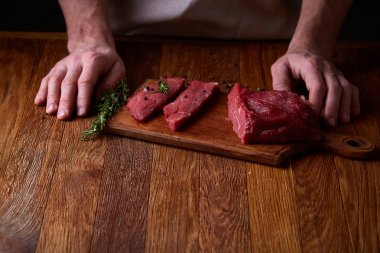Güçlü profesyonel kesme çiğ biftek, seçici odak, yakın çekim yakışıklı adamın