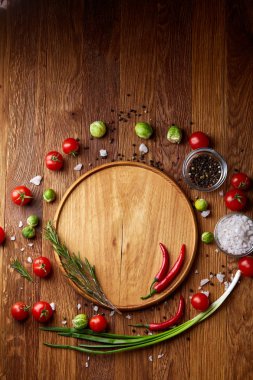 Görünümü çeşitli sebzeler, baharat ve spicies etrafında boş plaka üzerinde rustik ahşap arka plan, top