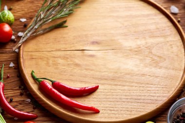 Görünümü çeşitli sebzeler, baharat ve spicies etrafında boş plaka üzerinde rustik ahşap arka plan, top