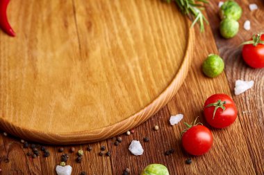 Görünümü çeşitli sebzeler, baharat ve spicies etrafında boş plaka üzerinde rustik ahşap arka plan, top