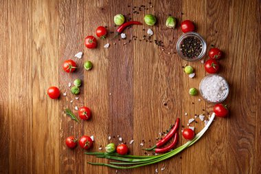 Görünümü çeşitli sebzeler, baharat ve spicies etrafında boş plaka üzerinde rustik ahşap arka plan, top