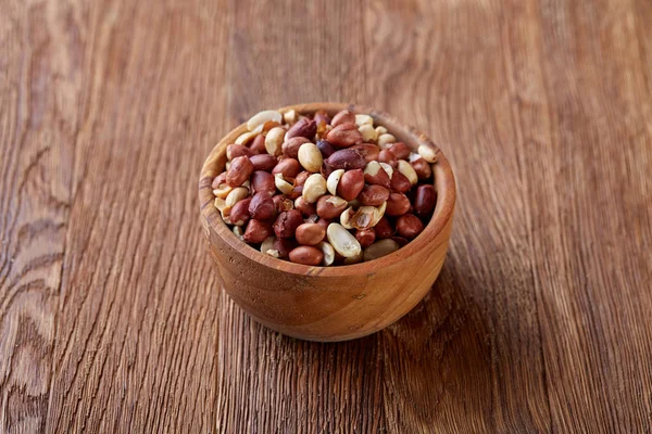Two ceramic bowls with raw peanuts mix isolated over rustic wooden backround, top view, close-up. — Stock Photo, Image