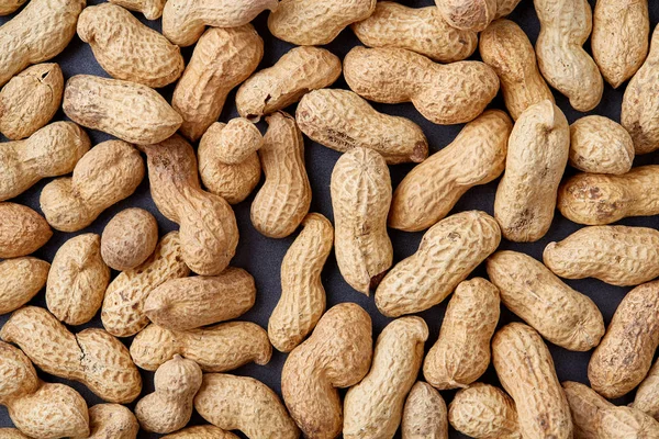 Tepsi üzerinde beyaz ekmek üzerinde soyulmamış çiğ fıstık dokulu arka plan, seçici odak, sığ derinlik-in tarla.