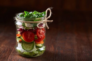 Kavanoz ve tablo, seçici odak, yakın çekim kesme tahtası üzerinde taze sebzeler lezzetli sebze salatası