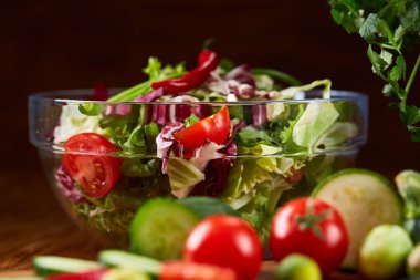 Taze sebze salatası ve olgun sebzeler üzerinde kesme ahşap arka plan üzerinde kurulu, seçici odak, yakın