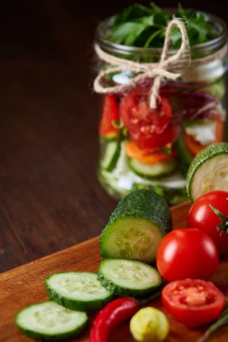 Kavanoz ve tablo, seçici odak, yakın çekim kesme tahtası üzerinde taze sebzeler lezzetli sebze salatası