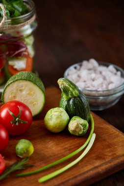 Kavanoz ve tablo, seçici odak, yakın çekim kesme tahtası üzerinde taze sebzeler lezzetli sebze salatası