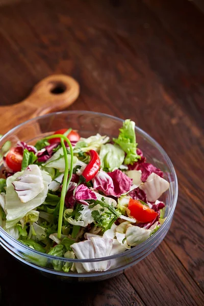 Délicieuse salade de légumes en pot et légumes frais sur planche à découper sur table, mise au point sélective, gros plan — Photo