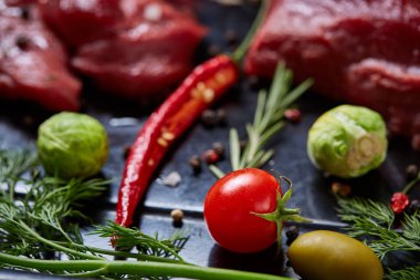 Sebzeler, otlar ve metal tepsi, yakın çekim, seçici odak spicies çiğ biftek düz lay