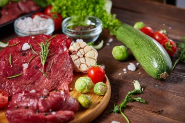 Natürmort ham sığır eti antika arka plan, üstten görünüm, seçici odak ahşap plaka üzerinde sebzeli