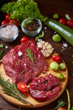 Natürmort ham sığır eti antika arka plan, üstten görünüm, seçici odak ahşap plaka üzerinde sebzeli