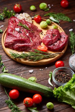 Natürmort ham sığır eti antika arka plan, üstten görünüm, seçici odak ahşap plaka üzerinde sebzeli